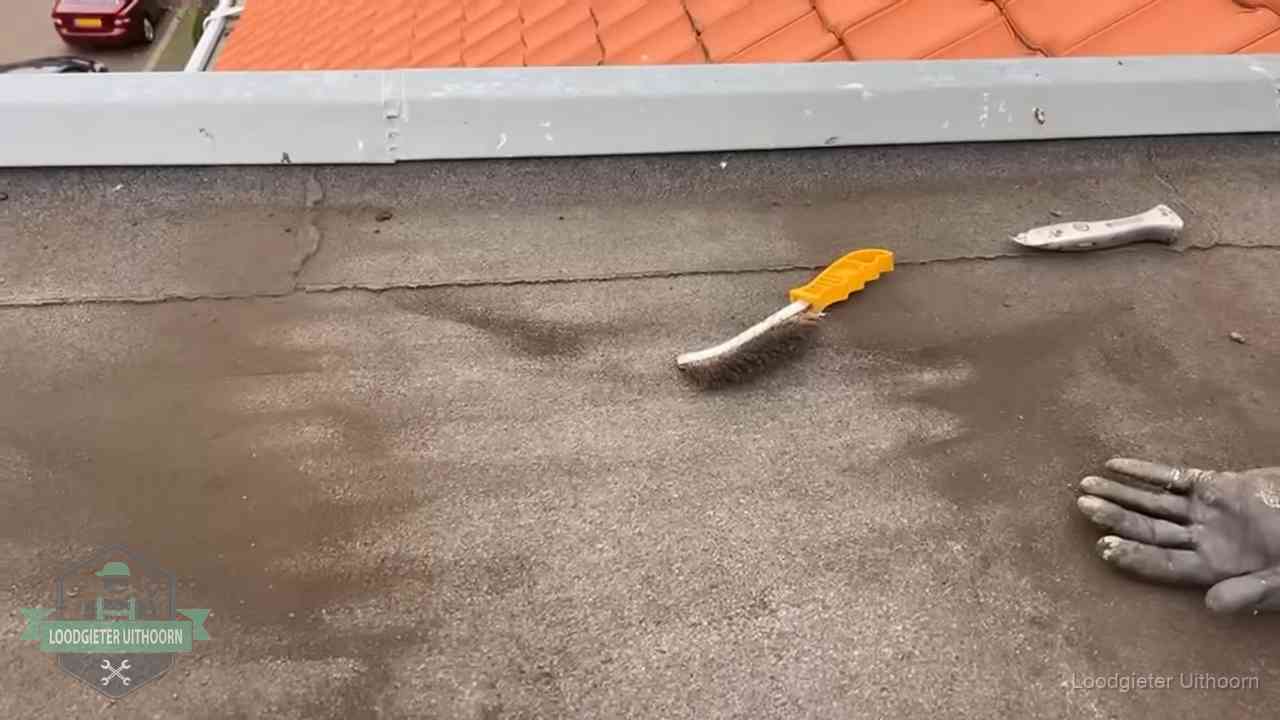 Kosten van daklekkage-reparatie in Uithoorn Dakdekker bereidt een bitumen plat dak voor op reparatie bij de daktrim in Uithoorn