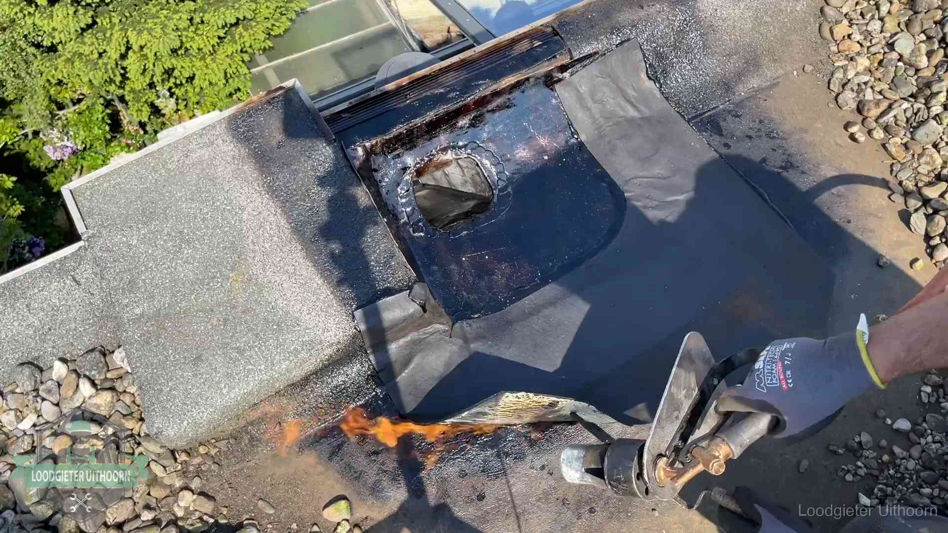 Daklekkage repareren in Uithoorn Dakdekker brandt bitumen rond een doorvoer tijdens een daklekkage-reparatie in Uithoorn