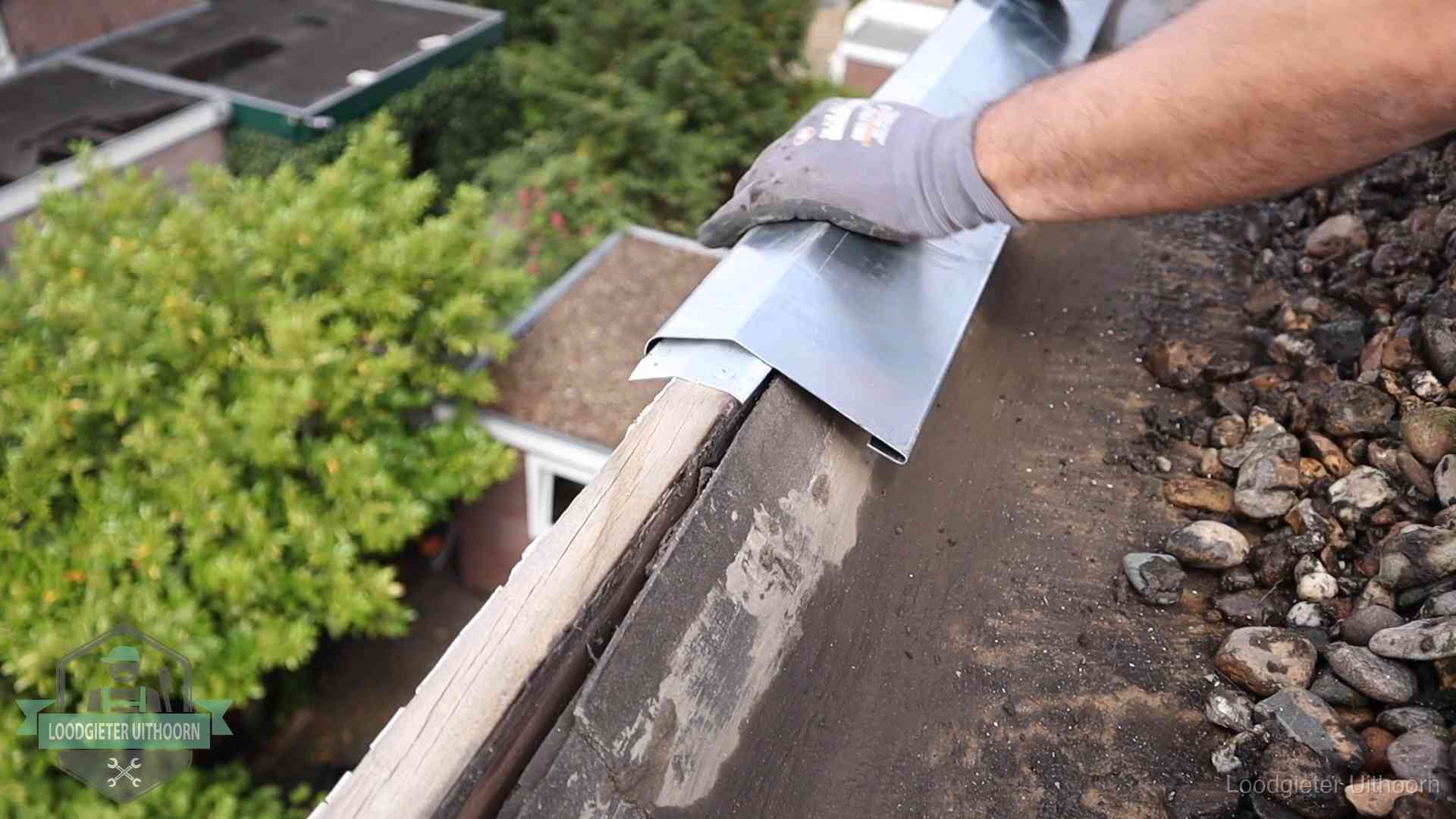 Daklekkage per wijk in Uithoorn Dakdekker plaatst een zinken deklijst op een dakrand met uitzicht over een woonwijk in Uithoorn