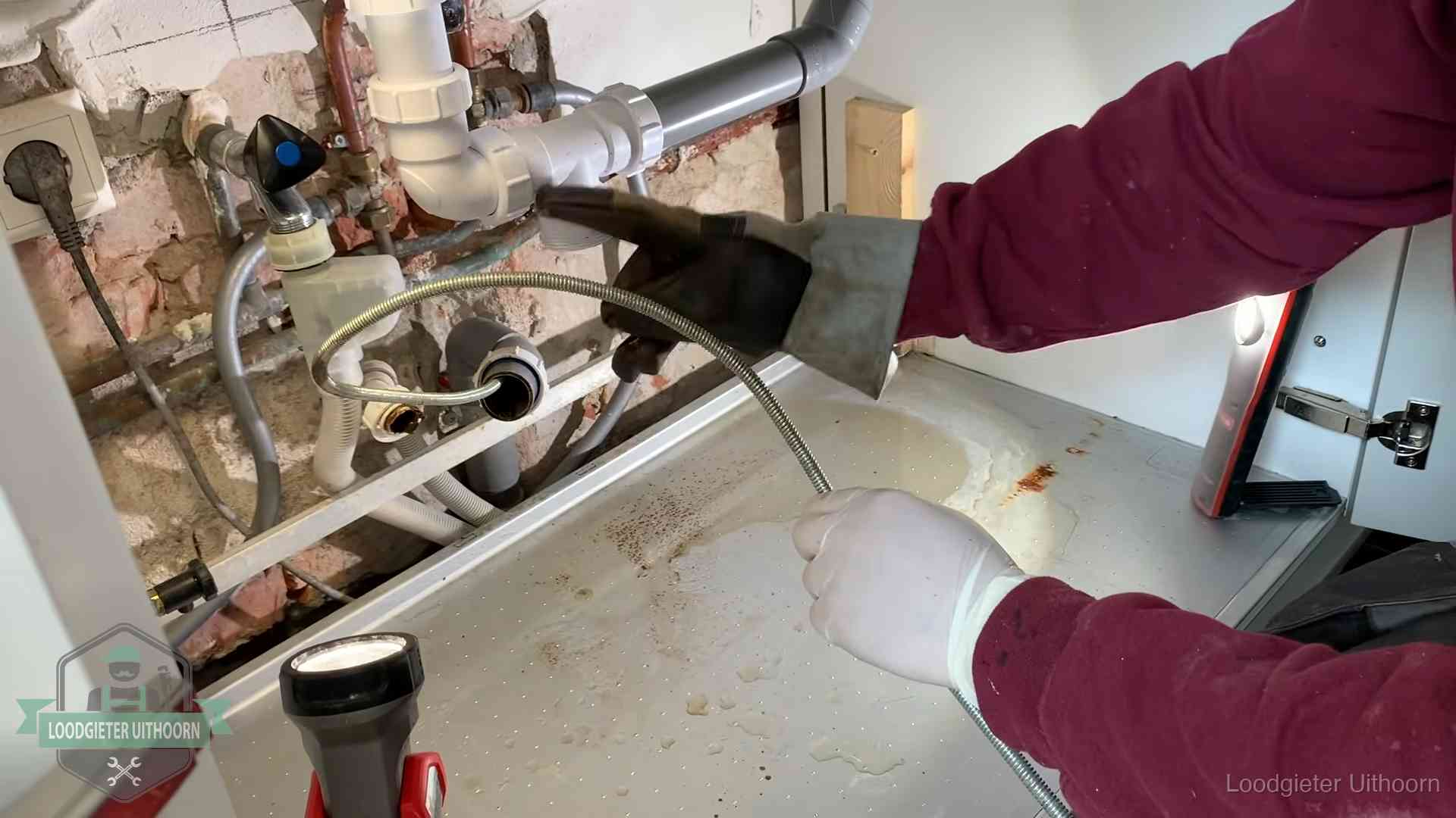 Spiraal of hogedruk in Uithoorn Ontstoppingsveer gaat in een geopende sifonaansluiting onder het aanrecht in Uithoorn