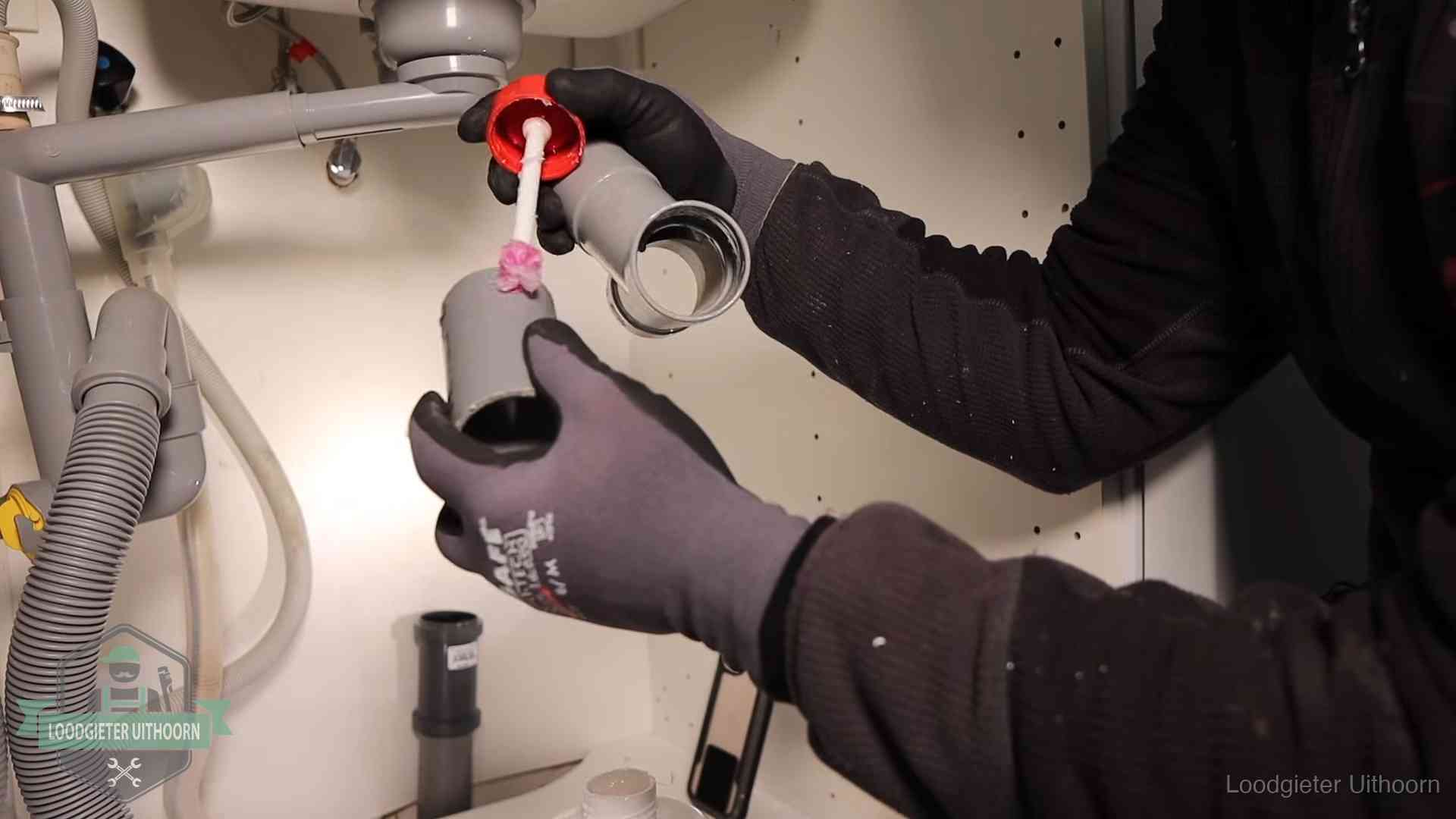 Oorzaak van een verstopte afvoer in Uithoorn Loodgieter demonteert en reinigt de sifon onder een keukenkast in Uithoorn