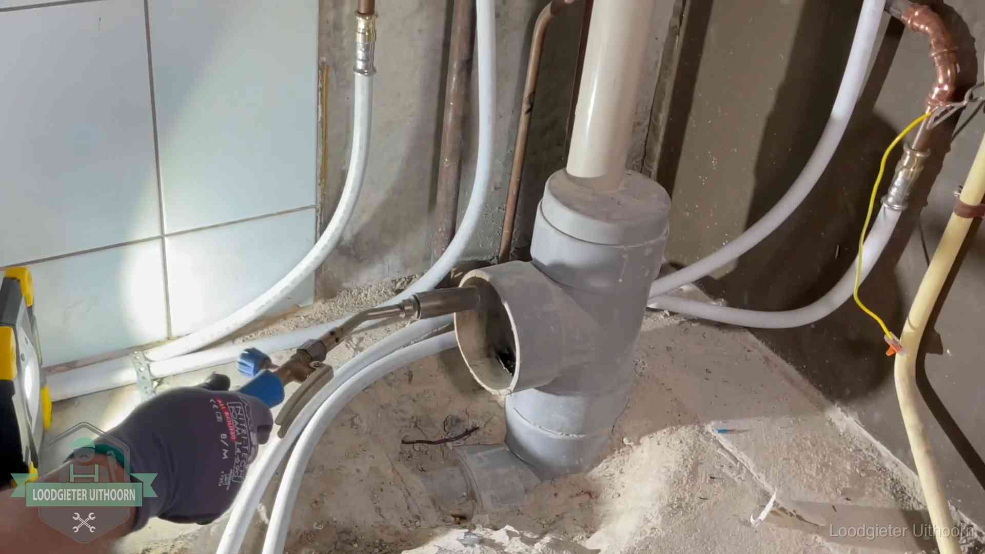 Verstopping in een huurwoning in Uithoorn Loodgieter werkt aan leidingen bij de pvc-standleiding van een huurwoning in Uithoorn