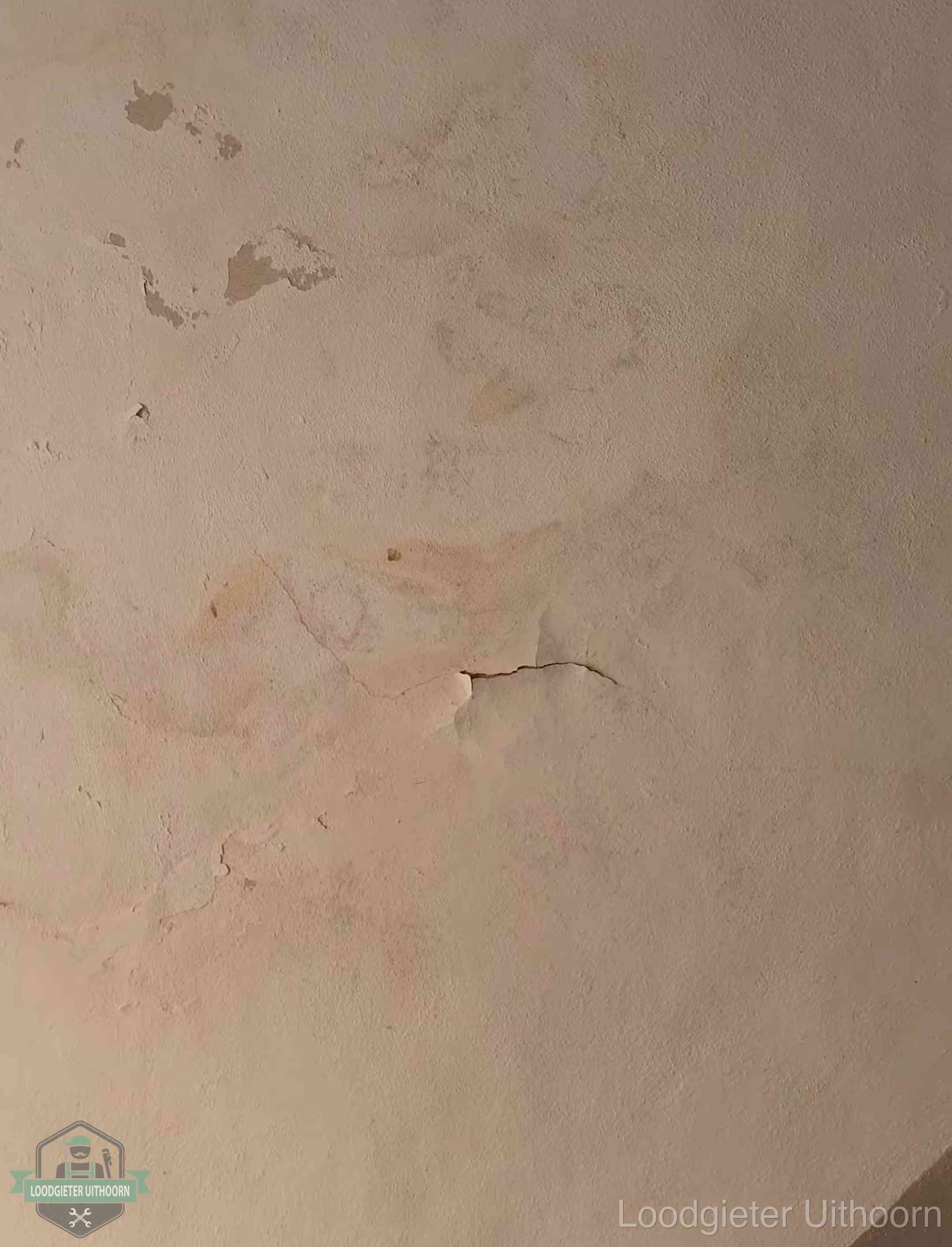 Vochtkringen en afbladderende verf op een plafond in Uithoorn, schade voor het meetrapport en de verzekering